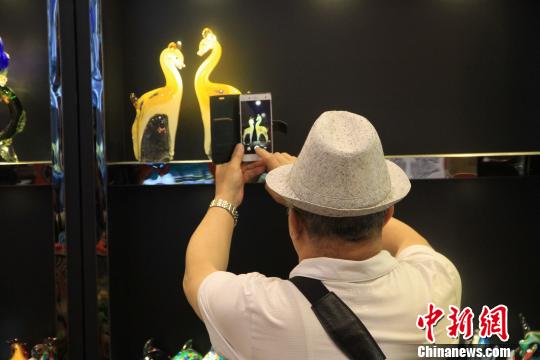 观展者对台湾琉璃工艺品进行拍照留念。 胡耀杰 摄
